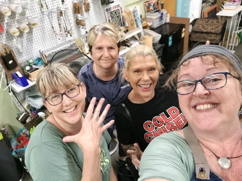 Four makers in the workshop holding up the rings they have just finished