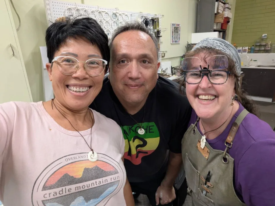 Storm with two students in the workshop, all smiling at the camera